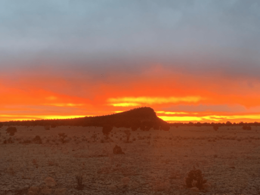 Orange Sunset over small mountain in Whiskey Creek Pack territory 