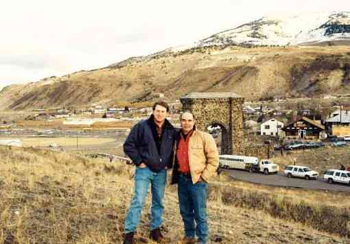 Rodger Schlickeisen and volunteer posing with Yellowstone arch and trailer 