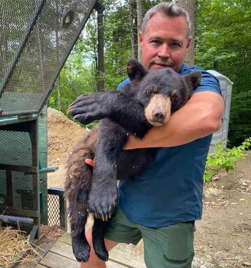 Jeff Corwin holding a black bear cub