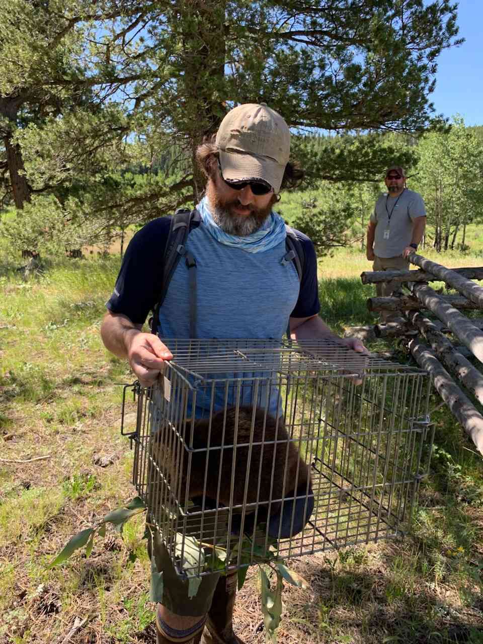 Aaron carrying beaver in cage