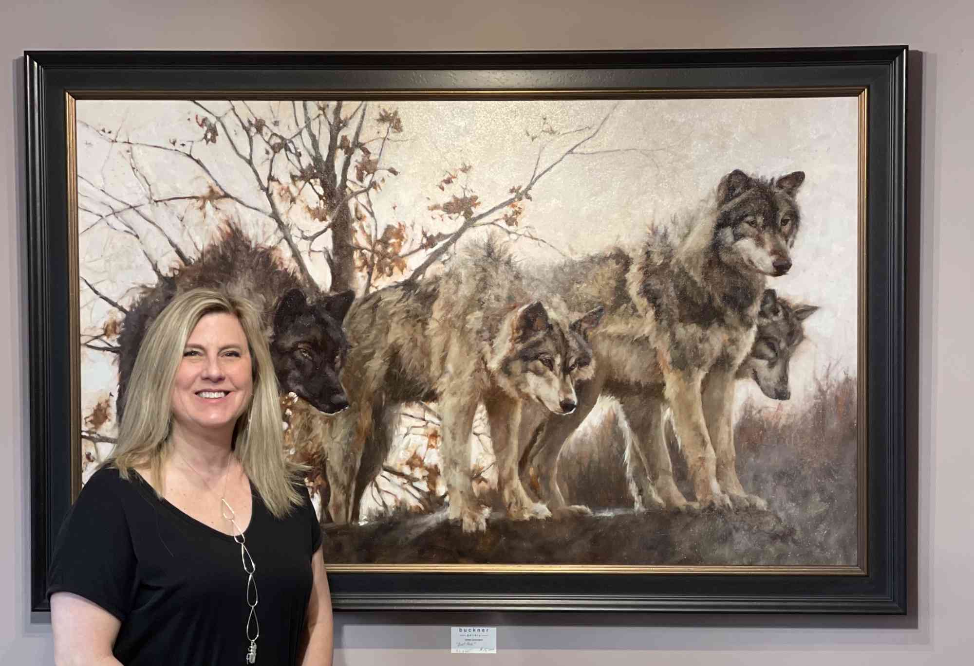 artist standing by wolf painting