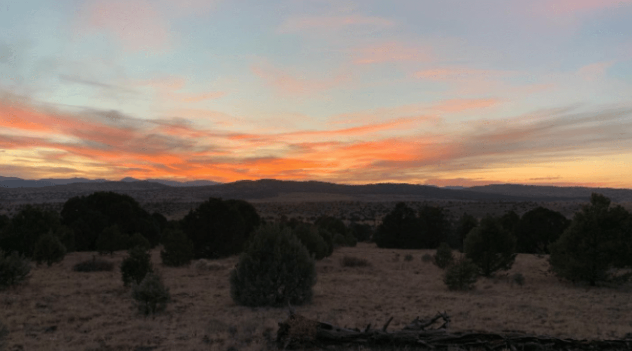 Orange sunset over mountains and bush plains 
