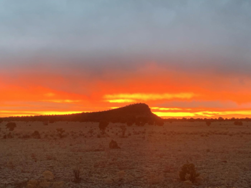 Orange Sunset over small mountain in Whiskey Creek Pack territory