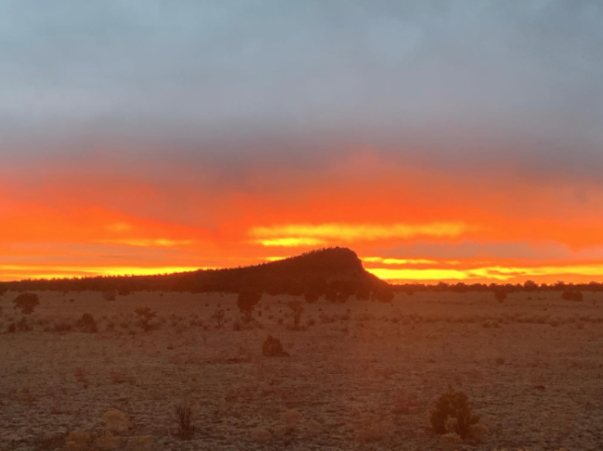 Orange Sunset over small mountain in Whiskey Creek Pack territory 