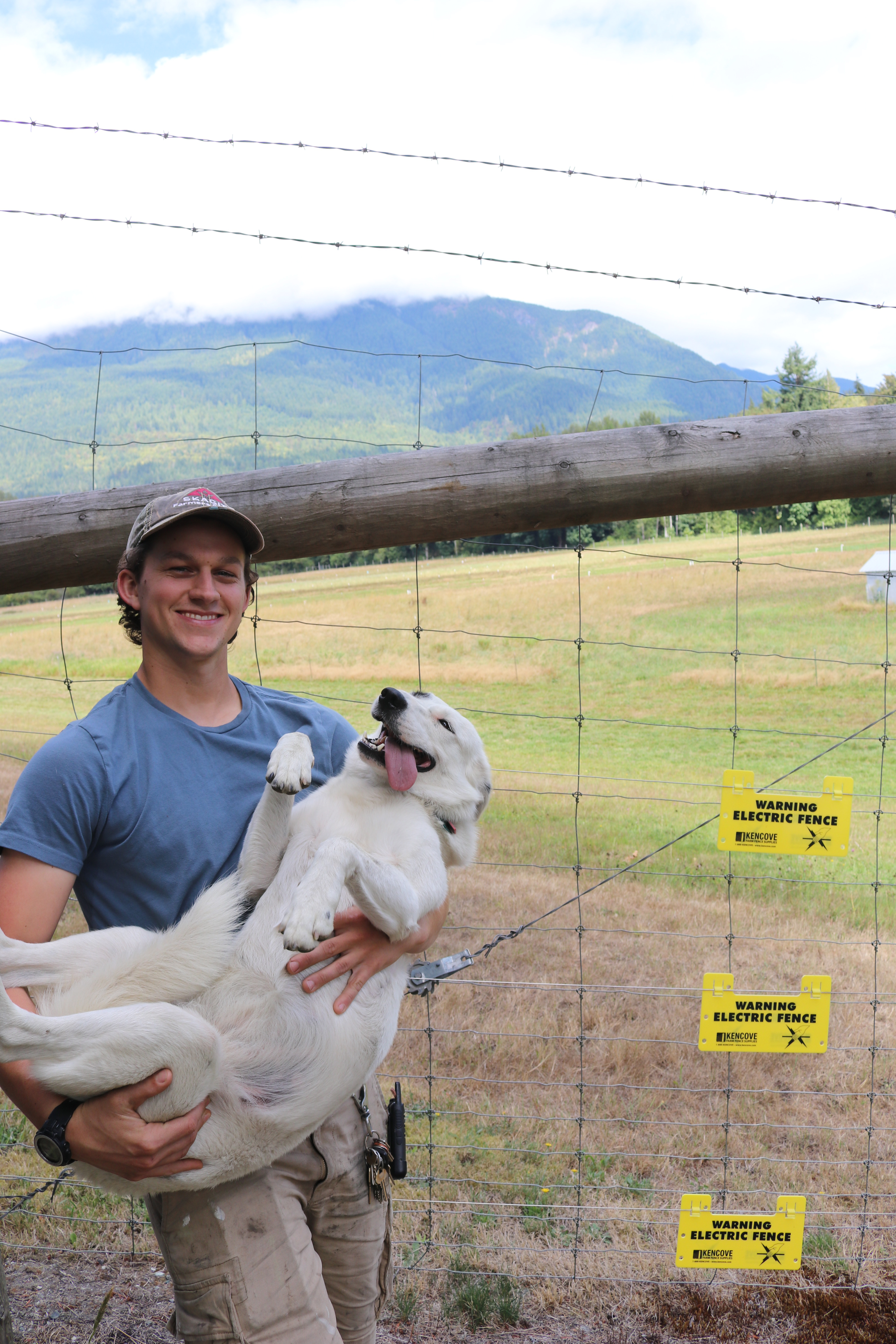 Griffin Berger (and Spot) by their electric fence on Sauk Farm